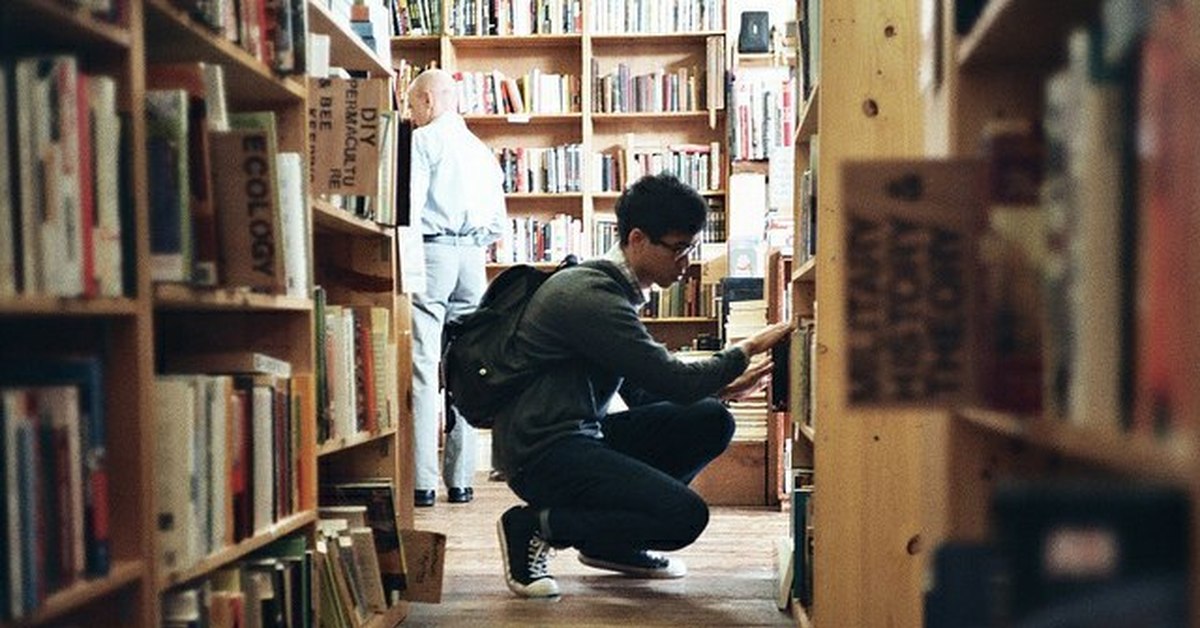 Она сидит в библиотеке. Мужчина в библиотеке. Чтение Эстетика. Мужчина с книгой. Юноша в библиотеке.