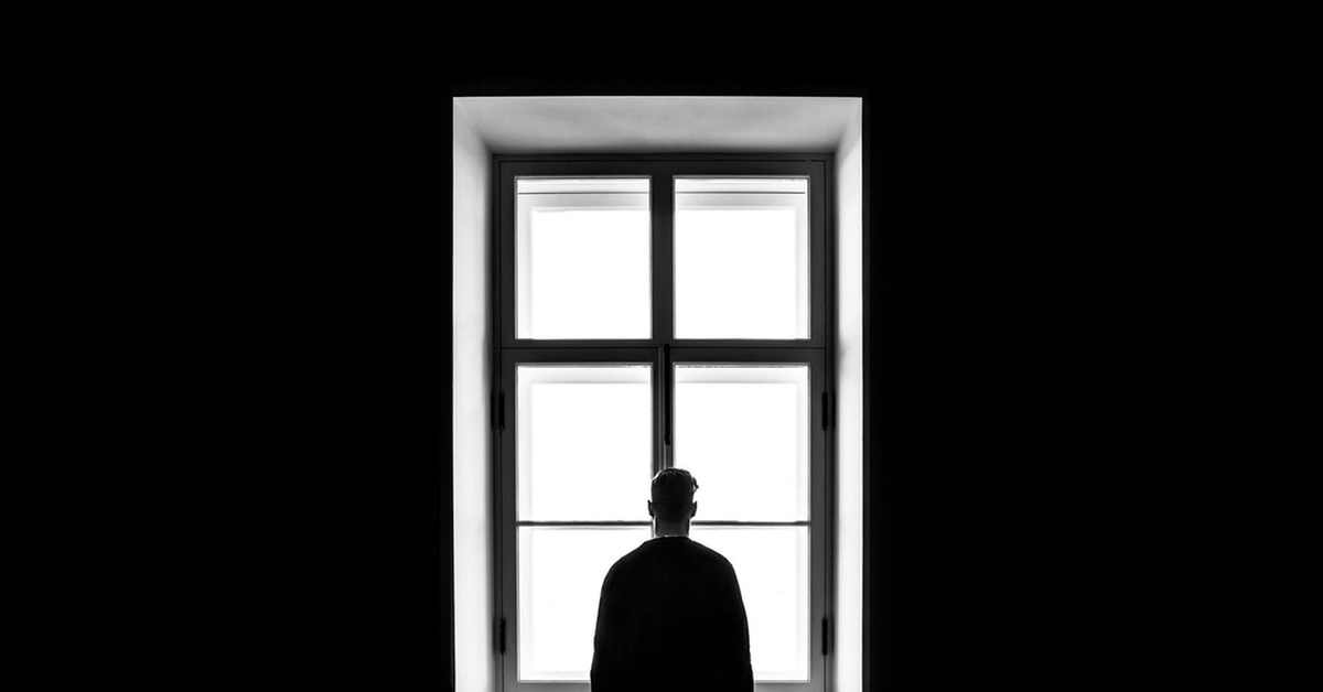 человек в глубокой задумчивости у старого окна