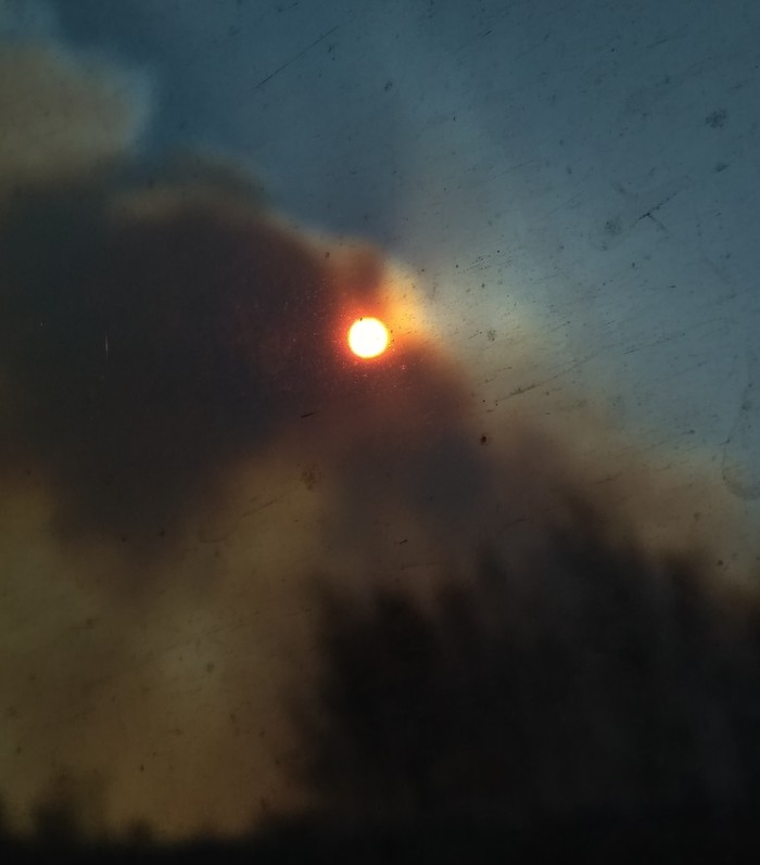 The sun breaks through the smoke, the view from the dirty window of the reserved seat. - Fire, My, The sun