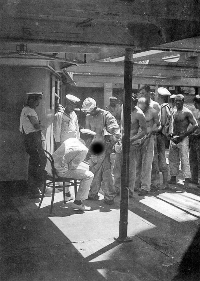 A ship's doctor examines the crew on their return from shore leave, 1910. - From the network, Sailors, Dismissal